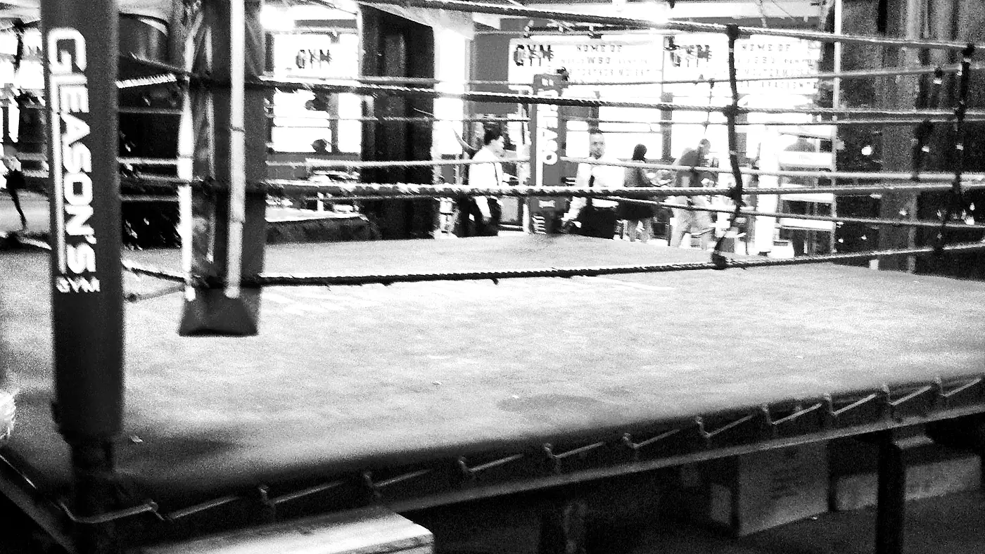 Leerer Boxring in einer Trainingshalle mit Neonlicht.